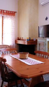 a kitchen with a wooden table with chairs and a tableablish at Villa Assunta in Tertenìa