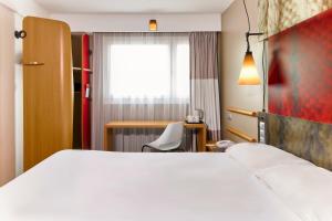 a hotel room with a white bed and a chair at ibis Bordeaux Centre - Gare Saint-Jean in Bordeaux