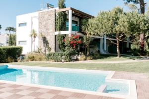a house with a swimming pool in front of a house at Sea Spot Soltróia in Carvalhal