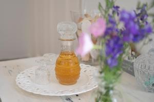 MK Apartment في لافريو: زجاجة من العسل على صحن بجوار بعض الزهور