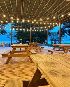 a group of picnic tables under a pavilion with lights at Bombay Camping Company, Pawna Lake Lonavala in Lonavala