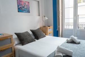una camera da letto con due letti e una finestra di Mar y Arte Apartamentos a Málaga
