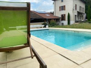 a chair sitting next to a swimming pool at Les Berouds in Salaise-sur-Sanne