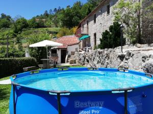 a swimming pool in a yard next to a building at Casa das Lages in Viariz
