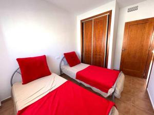 dwa łóżka w pokoju z czerwoną pościelą w obiekcie 3-bed sea view Penthouse, Isla Plana, Mojon Hills w mieście Isla Plana +16 zdjęć