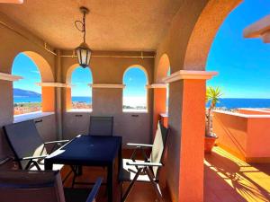 balkon ze stołem i krzesłami i widokiem na ocean w obiekcie 3-bed sea view Penthouse, Isla Plana, Mojon Hills w mieście Isla Plana