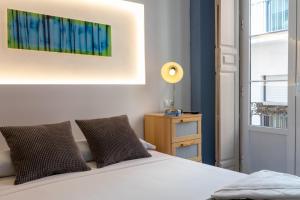 una camera da letto con un letto bianco e una finestra di Mar y Arte Apartamentos a Málaga