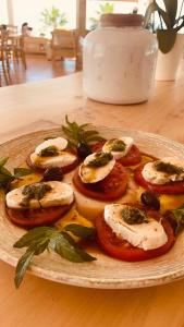 un plato de comida con tomates y aceitunas en una mesa en V-DelMar, en Vrachos