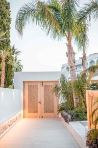 uma garagem de madeira com uma palmeira em frente em Vanik Suites em Kallithea Rhodes