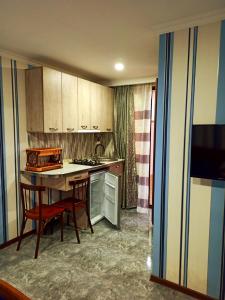 a kitchen with a table and two chairs and a counter at Guest house DAVID in Borjomi