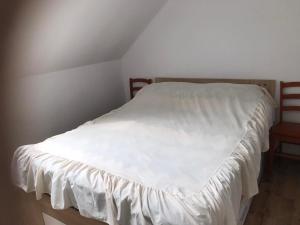 a bed with a white bedspread on it in a room at Apartament Mazurski Rodowo in Sorkwity