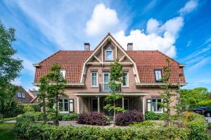 ein Haus mit rotem Dach in der Unterkunft Hotel Villa Vida in Domburg