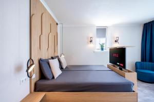 a small bedroom with a bed and a blue chair at B&B Hotel Villa Vida in Domburg