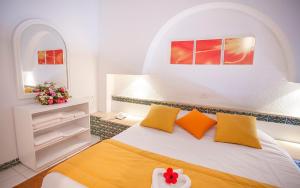 1 dormitorio con 1 cama con almohadas amarillas y naranjas en Seabel Aladin Djerba, en Aghīr