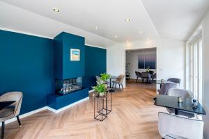 a living room with blue walls and a fireplace at Hotel Villa Vida in Domburg