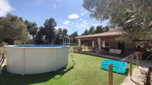 a hot tub in a yard next to a house at Mas del Olivar in La Portellada