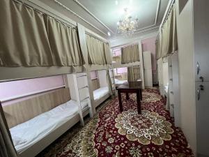 a room with two bunk beds and a table at Bruce hostel in Dushanbe