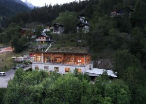 uma casa grande numa colina com árvores em WOO® Loft Resort em Fiesch