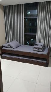 a bed sitting in front of a window at Casa Grande Residence Tower Angelo in Jakarta +25 photos