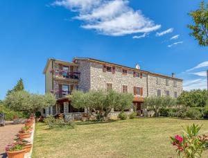 a large stone building with a yard in front of it at La Quiete B&B in Lovrečica