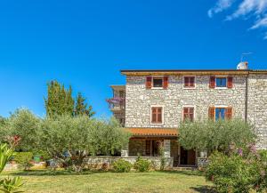 an old stone house with trees in front of it at La Quiete B&B in Lovrečica
