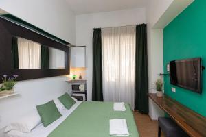 pokój hotelowy z łóżkiem i telewizorem z płaskim ekranem w obiekcie Internouno w Rzymie