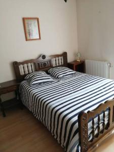a bedroom with a bed with a black and white striped blanket at La maison du Barbot Maison 6 couchages in Gujan-Mestras