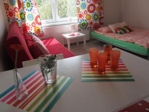 uma sala de estar com uma mesa com óculos laranja em Słoneczna Villa em Mrągowo