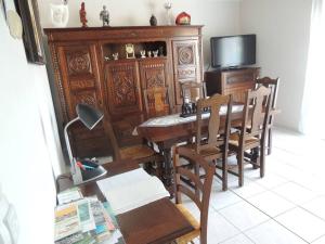 a dining room with a table and chairs and a television at La maison du Barbot Maison 6 couchages in Gujan-Mestras