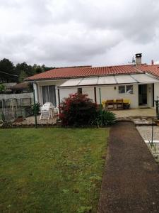 a white house with a red roof and a yard at La maison du Barbot Maison 6 couchages in Gujan-Mestras