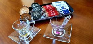 due vasi di vetro seduti su un tavolo con un vassoio di cibo di Apartamento Carmen a Morro del Jable