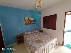 Schlafzimmer mit einem Bett mit blauer Wand in der Unterkunft Casa Grande in Camocim