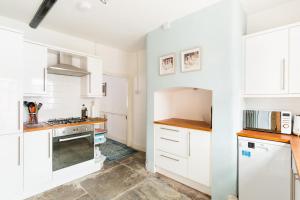 uma cozinha com armários brancos e um forno com placa de fogão em Shakespeare House Town Centre FREE Parking em Stratford-upon-Avon