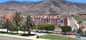 una città con palme e una montagna sullo sfondo di Apartamento Carmen a Morro del Jable