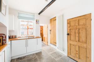 uma cozinha com armários brancos e uma porta de madeira em Shakespeare House Town Centre FREE Parking em Stratford-upon-Avon
