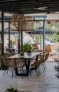 un patio con tavolo, sedie e ombrelloni di Bitzaro Palace Hotel a Kalamákion