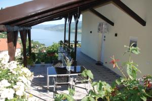 a patio with a table and chairs and a view of the water at Apartment Danubius in Donji Milanovac