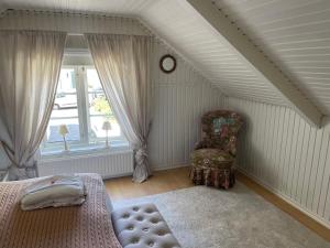 ein Schlafzimmer mit einem Bett, einem Stuhl und einem Fenster in der Unterkunft Pia's House in Göteborg