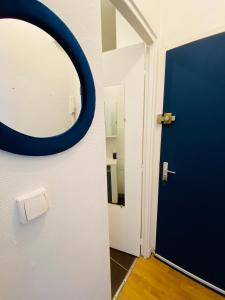 a bathroom with a blue door and a mirror at Superbe studio au pied de la gare de Caen in Caen