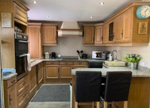 a kitchen with wooden cabinets and a counter top at Kingsway Lodge in London