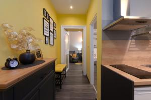 a kitchen with yellow walls and a counter with a vase at Apartment Korzo Filodrammatica in Rijeka