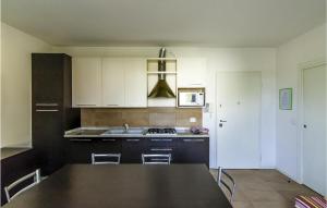 een keuken met een zwarte tafel en witte kasten bij Cozy Apartment In Cavallino-treporti With Wifi in Cavallino-Treporti