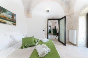a living room with a green and white couch at Suite Fronte Valle in Cisternino