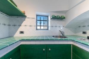 a kitchen with green cabinets and a sink at Suite Fronte Valle in Cisternino +18 photos