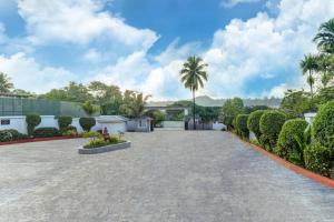 a driveway in front of a house with palm trees at Lemon Tree Hotel, Port Blair in Port Blair