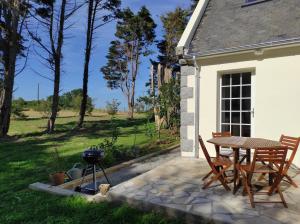 a patio with a table and chairs and a grill at Ty gwenn in Cancale