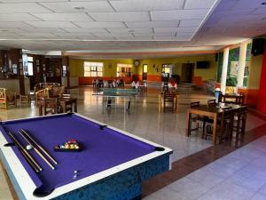 a pool table in a room with tables and chairs at Hotel Tres Flores in Huasca de Ocampo