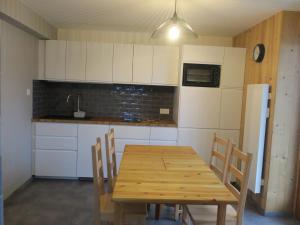 eine Küche mit Holztisch und Kühlschrank in der Unterkunft Appartement cosy à Châtel - 5 pers, WIFI - FR-1-198-207 in Châtel