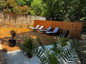 un patio con sedie, tavoli e un muro di mattoni di Villa QUINISSOLE a Sainte-Anastasie-sur-Issole