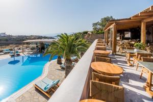 a resort with a pool and tables and chairs at San Antonio Summerland in Mýkonos City
